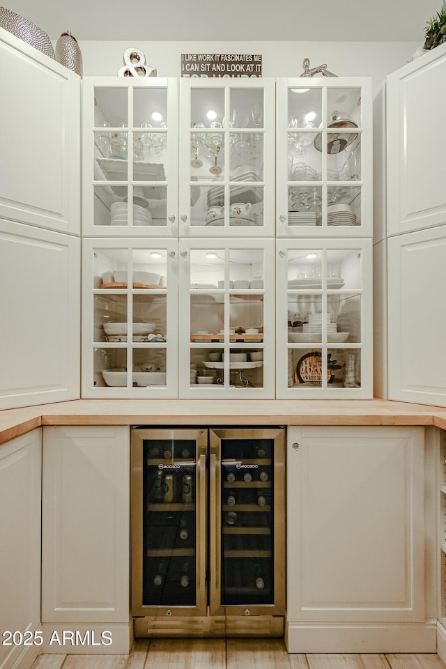 bar with beverage cooler and white cabinets