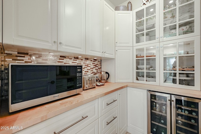 bar featuring wine cooler, white cabinets, and decorative backsplash