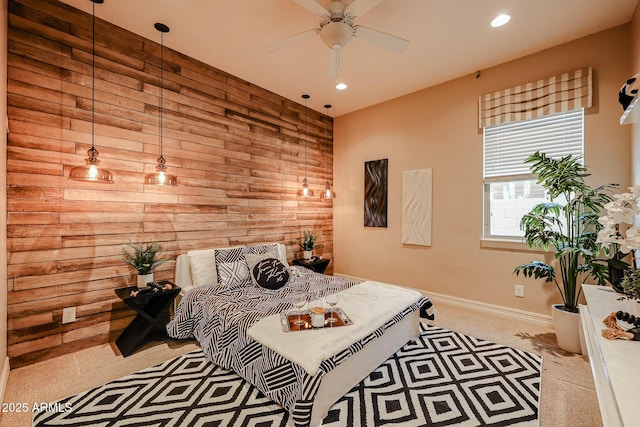 bedroom featuring ceiling fan and wooden walls