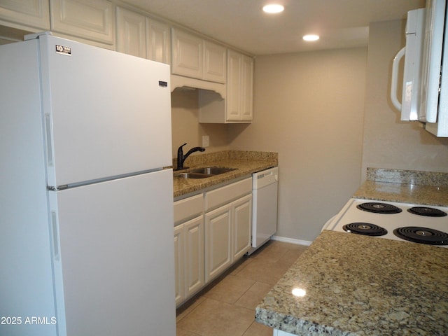 kitchen with white appliances, white cabinets, light tile patterned floors, and sink