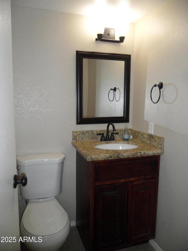 bathroom featuring toilet and vanity