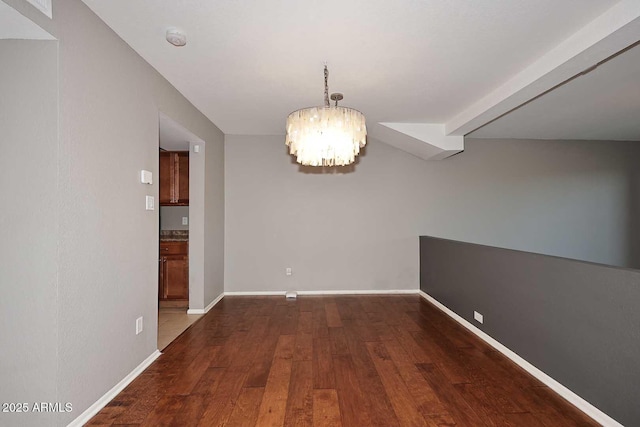 unfurnished dining area with dark hardwood / wood-style floors and a notable chandelier