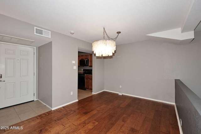 unfurnished dining area with hardwood / wood-style flooring and a notable chandelier