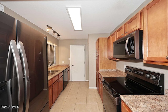 kitchen with rail lighting, sink, light tile patterned floors, stainless steel appliances, and light stone countertops