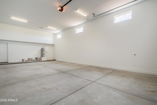 garage featuring a garage door opener, electric water heater, and baseboards