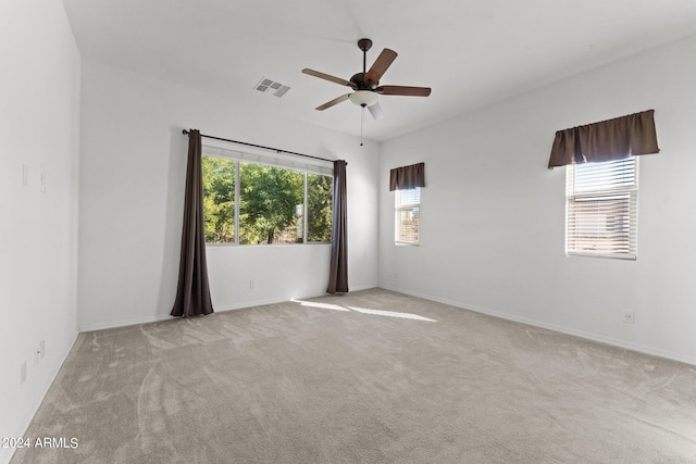 spare room featuring a ceiling fan, visible vents, and carpet flooring