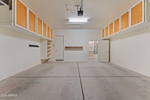 garage featuring water heater, baseboards, and a garage door opener