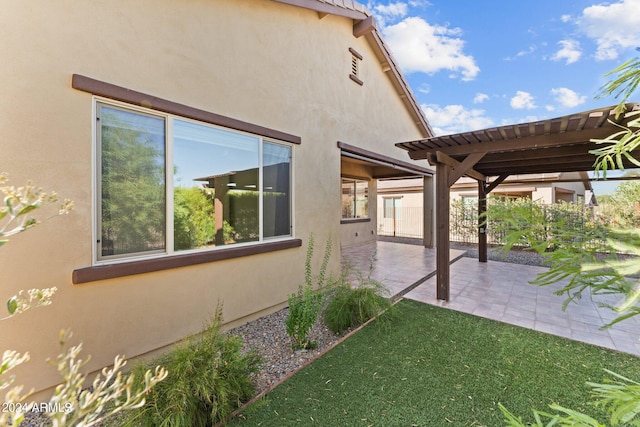 view of side of home with a patio, a pergola, and stucco siding