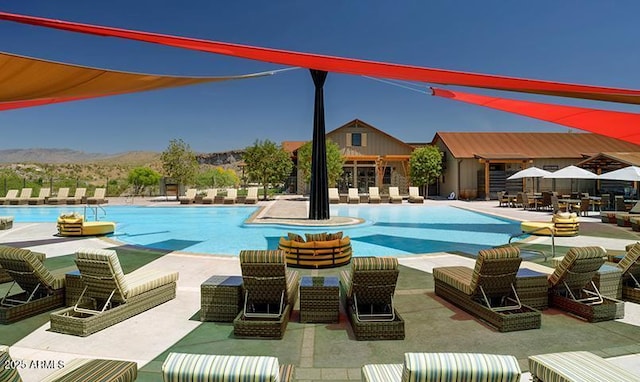 pool featuring a patio, outdoor lounge area, and a mountain view