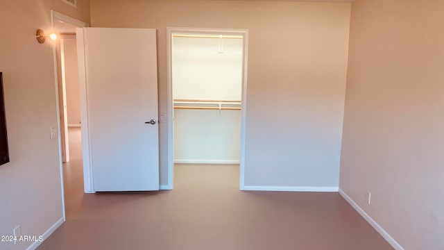 unfurnished bedroom with a closet and concrete floors