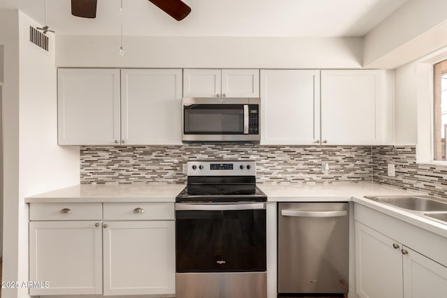 kitchen featuring white cabinets, stainless steel appliances, and light countertops