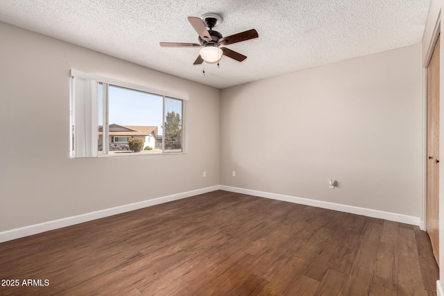 empty room featuring dark wood-style floors, baseboards, ceiling fan, and a textured ceiling