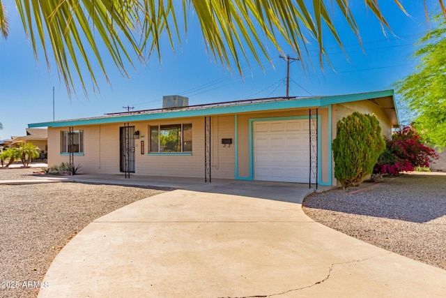 ranch-style house with metal roof, concrete driveway, and an attached garage
