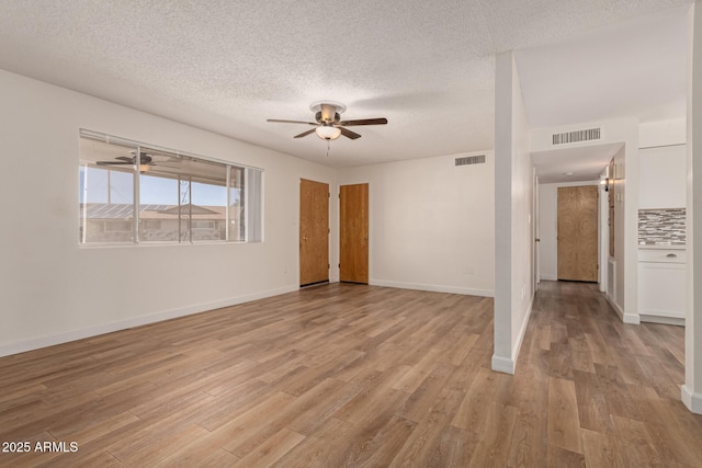 interior space featuring a textured ceiling, ceiling fan, light wood-style flooring, and visible vents