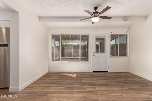 unfurnished room featuring a textured ceiling, a ceiling fan, and baseboards