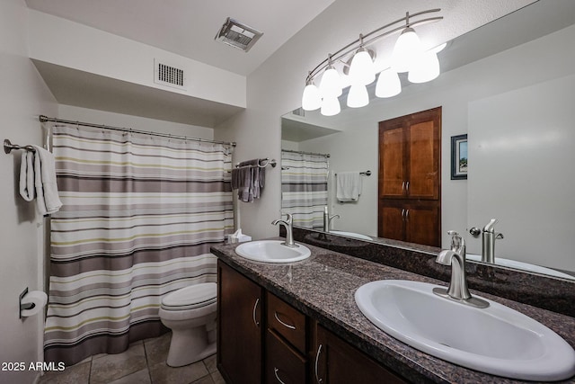 bathroom with toilet, vanity, and tile patterned flooring