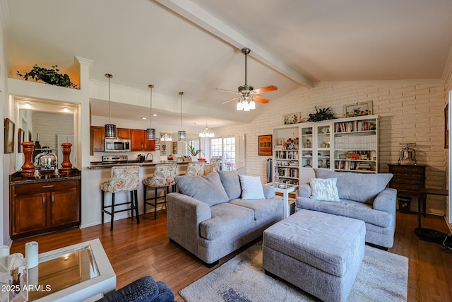 living room with ceiling fan, brick wall, dark hardwood / wood-style flooring, and vaulted ceiling with beams