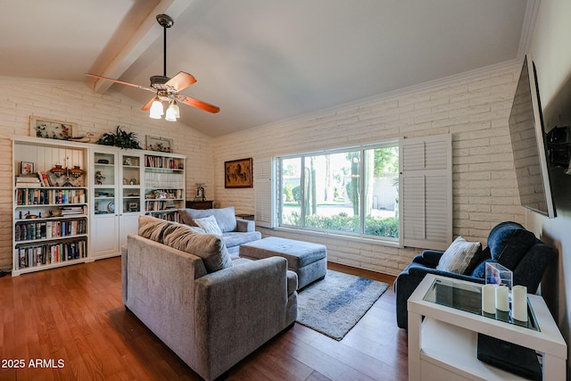 living room featuring dark hardwood / wood-style flooring, lofted ceiling with beams, ceiling fan, and brick wall