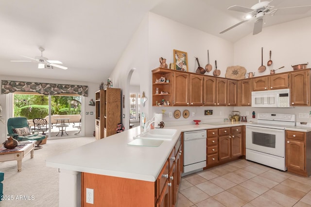 kitchen with sink, light tile patterned floors, ceiling fan, kitchen peninsula, and white appliances