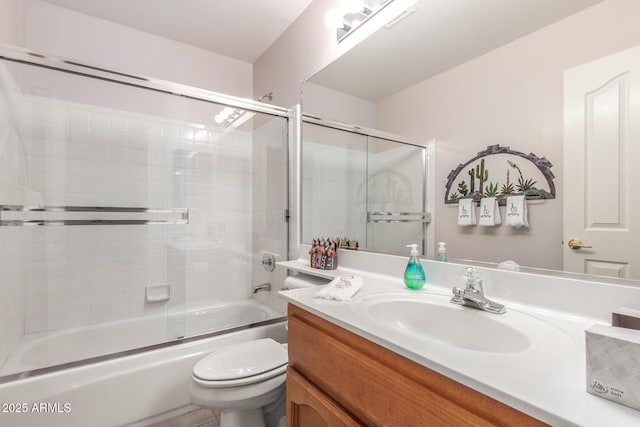 full bathroom featuring vanity, shower / bath combination with glass door, and toilet