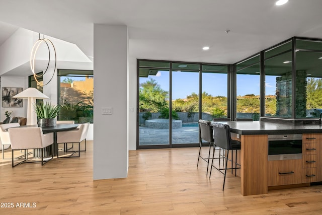 interior space with light wood-style flooring, expansive windows, and recessed lighting