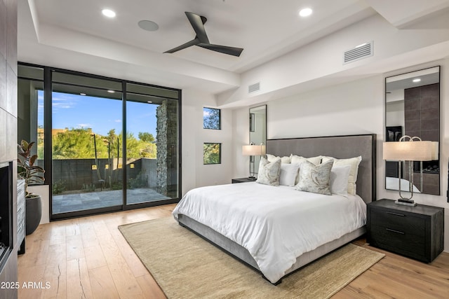 bedroom with access to outside, visible vents, and hardwood / wood-style floors