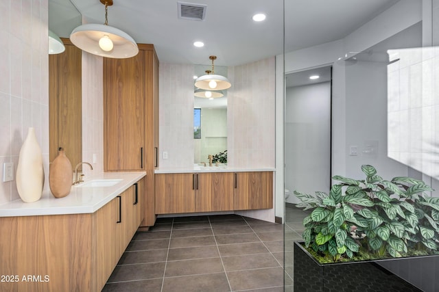 bathroom with vanity, visible vents, tile walls, and tile patterned floors