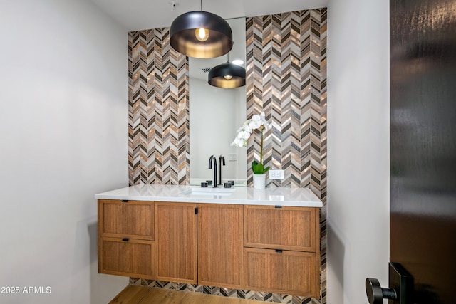 bar featuring a sink, tile walls, and decorative light fixtures