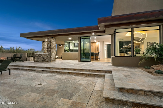 rear view of property with stucco siding and a patio