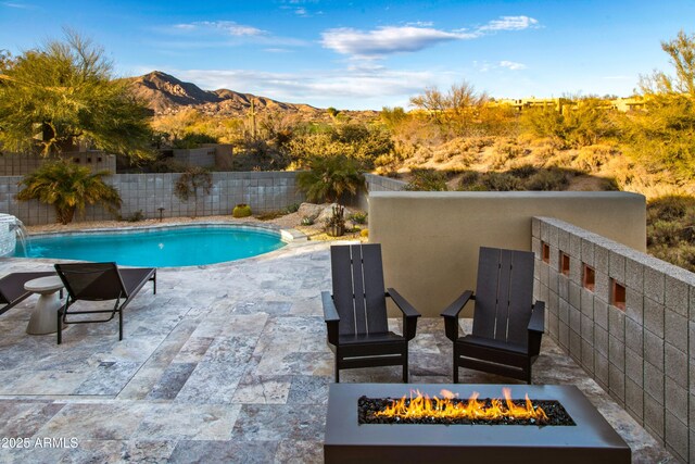 view of swimming pool featuring an outdoor fire pit, a fenced in pool, a patio, a fenced backyard, and a mountain view