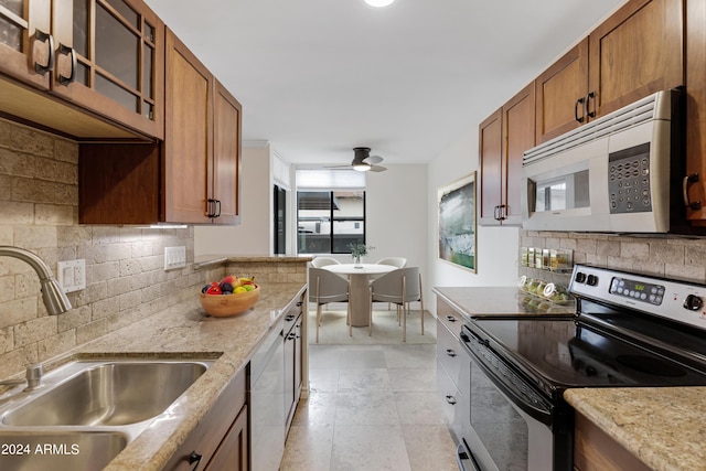 kitchen featuring tasteful backsplash, sink, ceiling fan, light stone counters, and white appliances