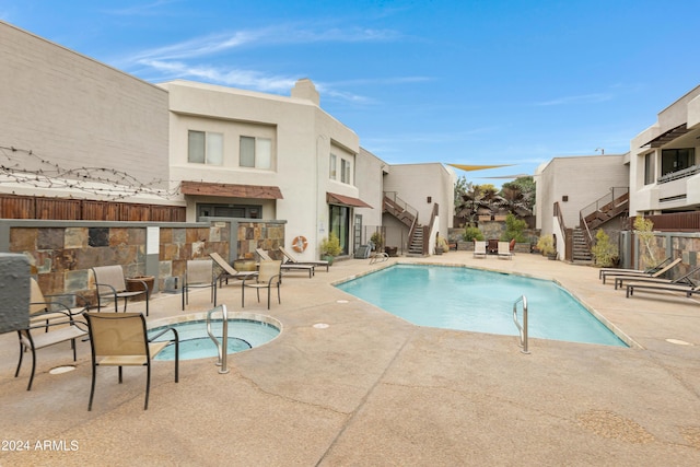 view of swimming pool featuring a patio and a community hot tub