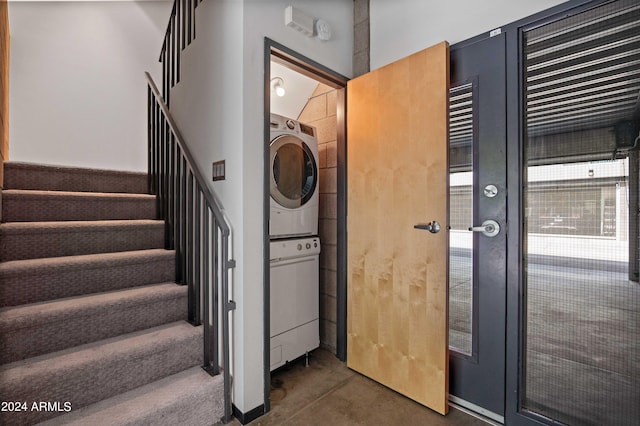 interior space featuring stacked washing maching and dryer and concrete flooring