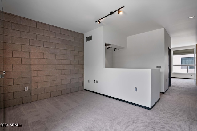 carpeted spare room featuring track lighting