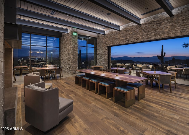 dining room with wood-type flooring, a mountain view, beamed ceiling, and wooden ceiling