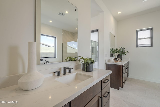 full bath featuring a healthy amount of sunlight, vanity, visible vents, and recessed lighting