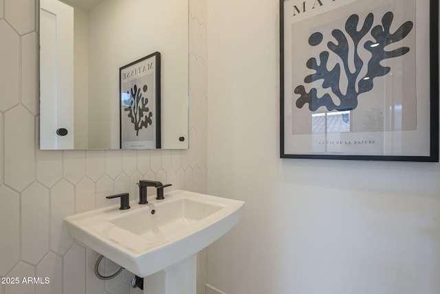bathroom featuring a sink and tasteful backsplash