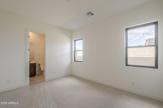 empty room featuring visible vents, baseboards, light colored carpet, and a healthy amount of sunlight