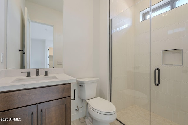 bathroom featuring a shower stall, toilet, and vanity