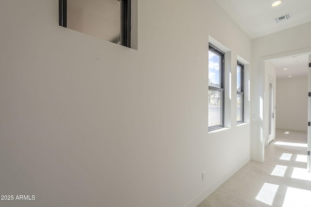 hall featuring baseboards, visible vents, recessed lighting, and light tile patterned floors