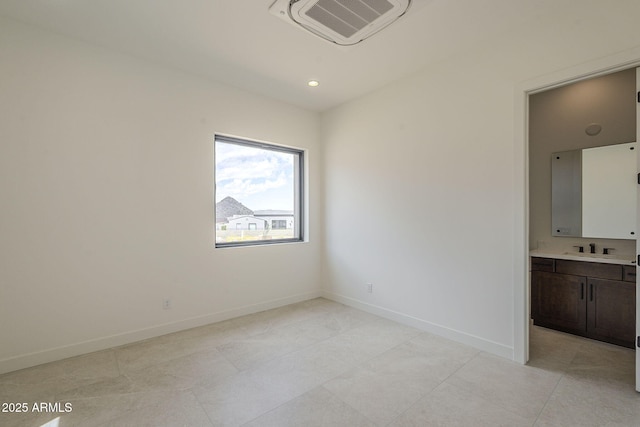 unfurnished bedroom with baseboards, visible vents, connected bathroom, and a sink