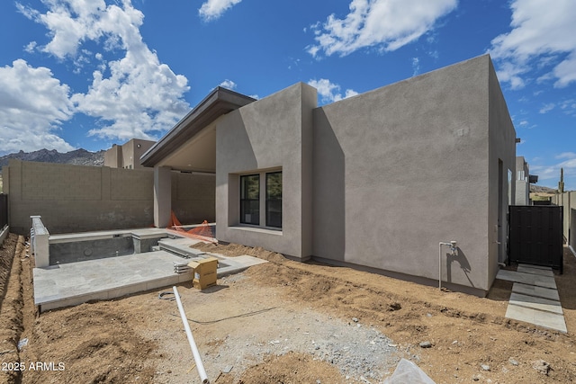 rear view of property with a fenced backyard and stucco siding