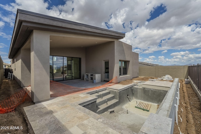 back of property with a fenced backyard, a patio, and stucco siding