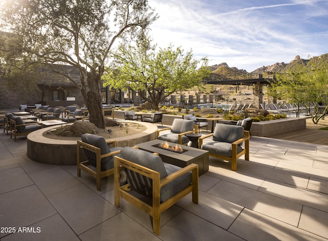 view of patio / terrace with an outdoor living space with a fire pit and a mountain view