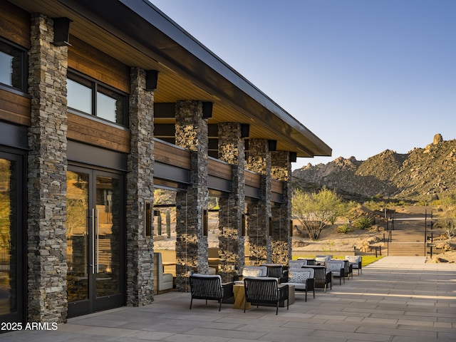 view of patio featuring french doors, a mountain view, and an outdoor hangout area