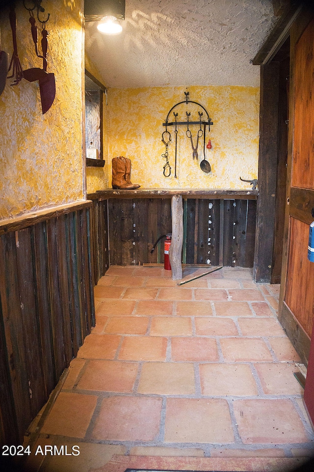 interior space with wood walls and a textured ceiling