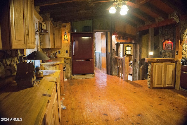 kitchen with vaulted ceiling with beams, hardwood / wood-style flooring, ceiling fan, and refrigerator