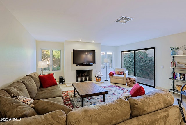 living room with recessed lighting, visible vents, and a fireplace