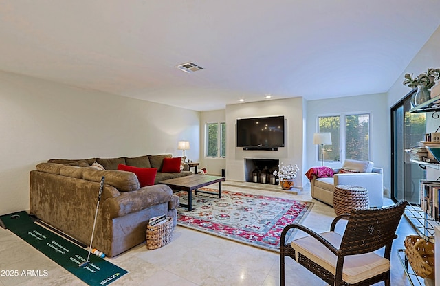 living area featuring visible vents and a fireplace with raised hearth