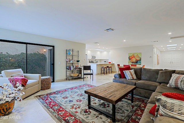 living room with recessed lighting, visible vents, and baseboards